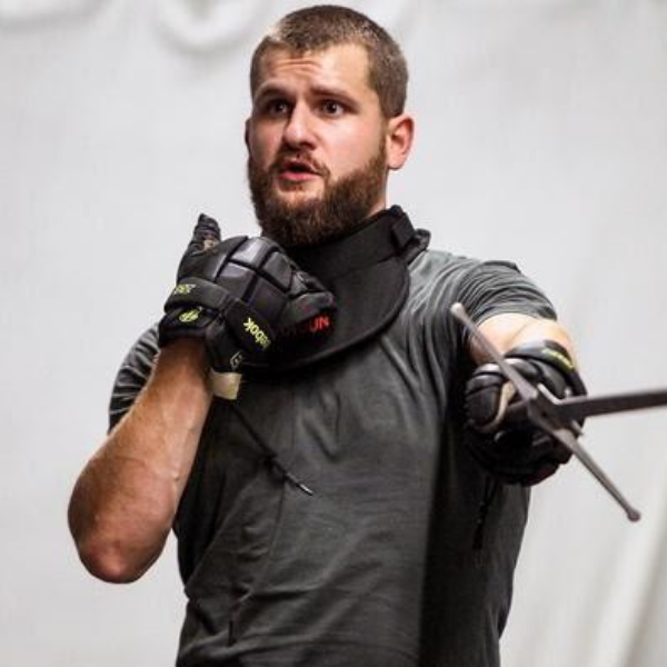 Coach Bryant training students in sword fighting.