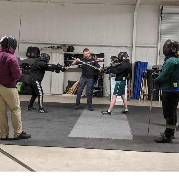 Coach showing students how to use weapons during class